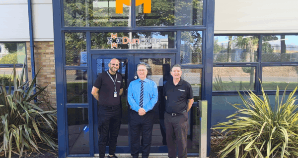 Three men standing in front of Mackenzie Construction's new Dundee hub